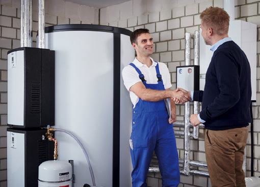 Monteur übergibt neue Wärmepumpe und Pufferspeicher an Kunden – Garantie und Service durch Dein Energiehaus
