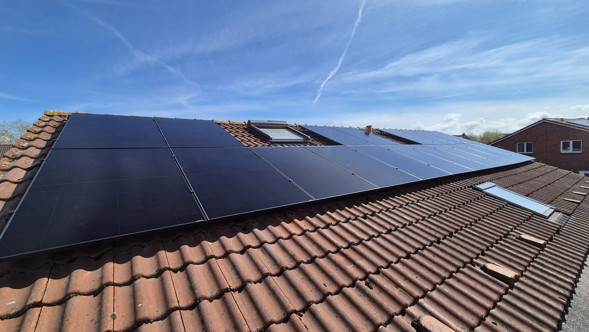 Full-Black-PV-Module auf rotem Ziegeldach eines Reihenhauses in Düsseldorf-Gerresheim – Nahaufnahme